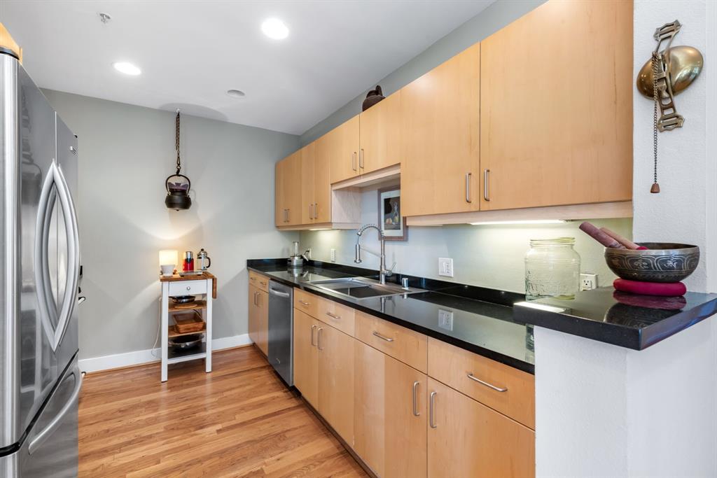 5055 Addison Circle, Unit 733 Addison, TX 75001 - Photo 11 of 40 a kitchen with granite countertop a sink and cabinets