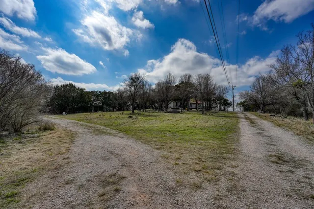 a view of a car parked in the road and trees