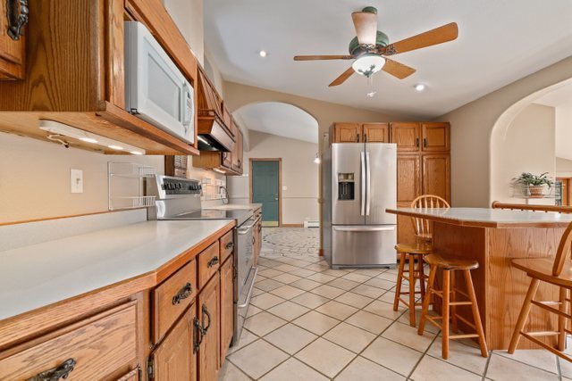 2202 Stieg Road Woodstock, IL 60098 - Photo 5 of 55 a kitchen with stainless steel appliances kitchen island granite countertop furniture and a refrigerator