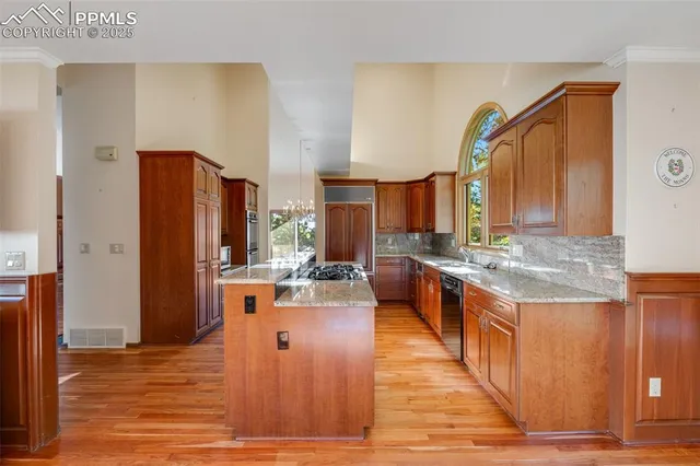 a large kitchen with stainless steel appliances a stove refrigerator a sink dishwasher and wooden floor