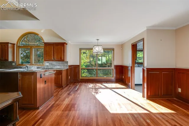 a open kitchen with granite countertop a stove a sink a refrigerator and wooden floors