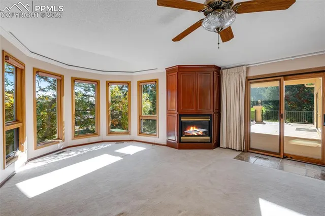 an empty room with windows and fireplace