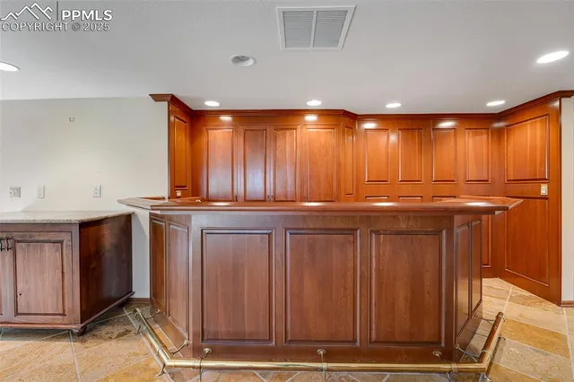 a view of an empty room with wooden floor and windows