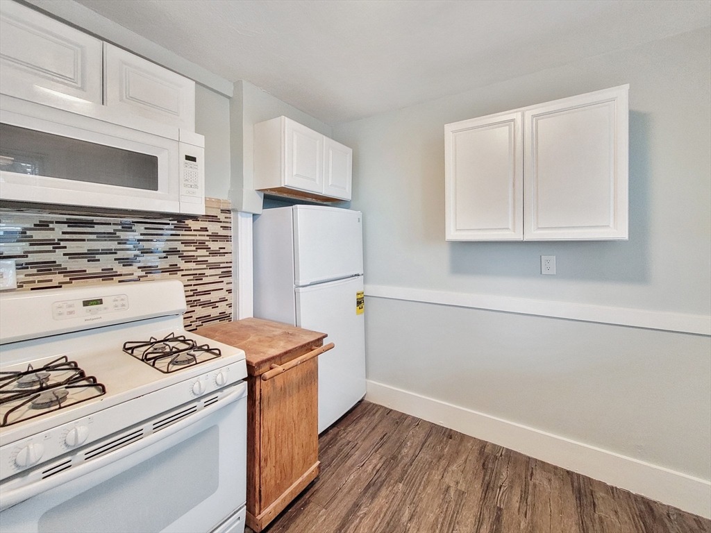 31-35 Juniper Street, Unit 31 1 Boston, MA 02119 - Photo 9 of 12 a kitchen with a stove and a refrigerator