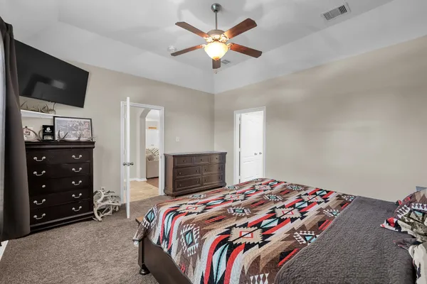a bedroom with a bed chandelier and a window