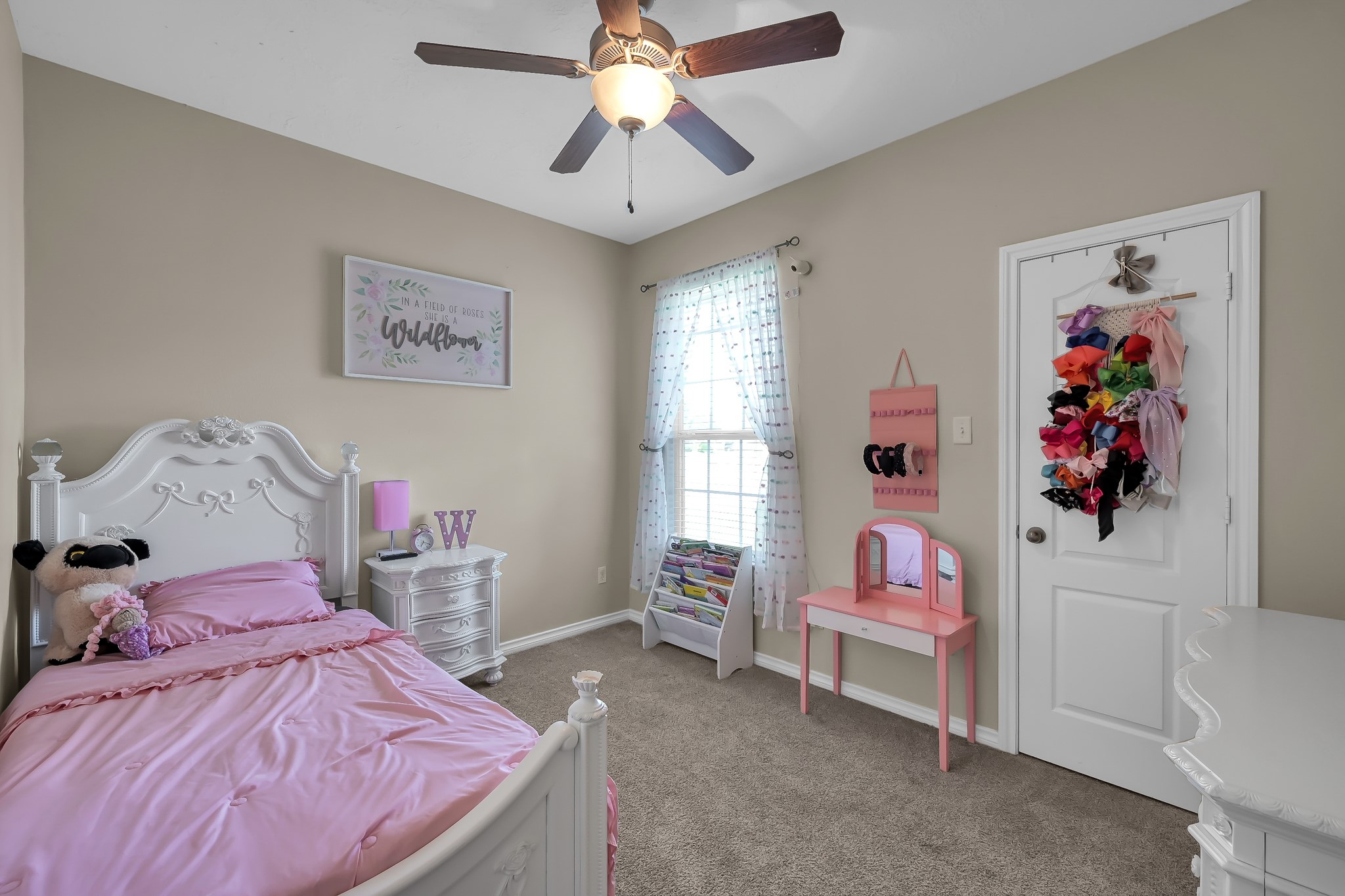 409 Mildred Street Cleveland, TX 77328 - Photo 14 of 24 a bedroom with a bed and a chandelier