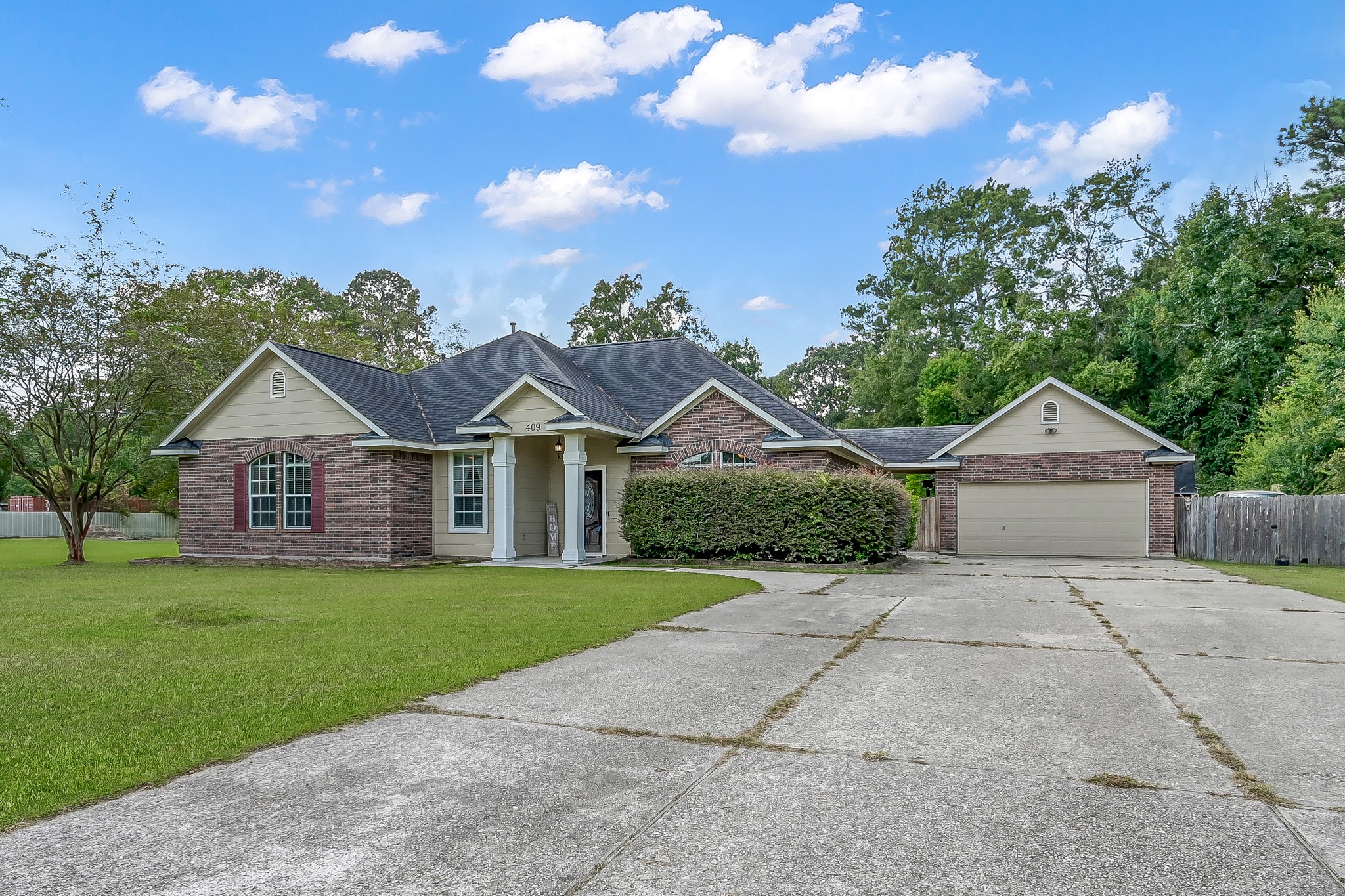 409 Mildred Street Cleveland, TX 77328 - Photo 23 of 24 a front view of a house with a garden and yard