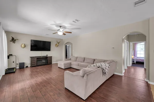 a living room with furniture and a wooden floor