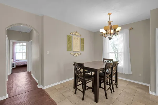a dining room filled chandelier and kitchen view