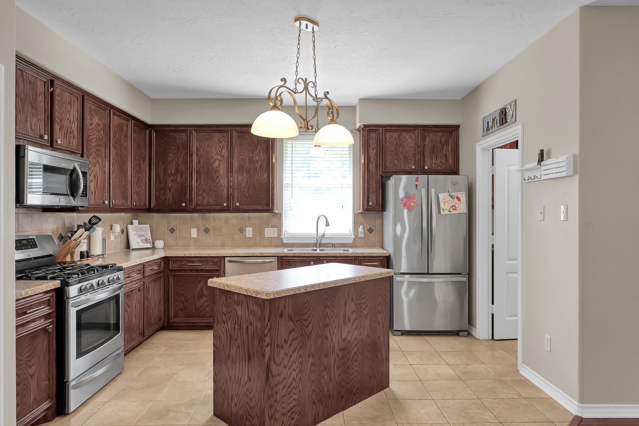 409 Mildred Street Cleveland, TX 77328 - Photo 8 of 24 a kitchen with stainless steel appliances granite countertop a refrigerator a sink dishwasher a stove top oven a refrigerator and cabinets