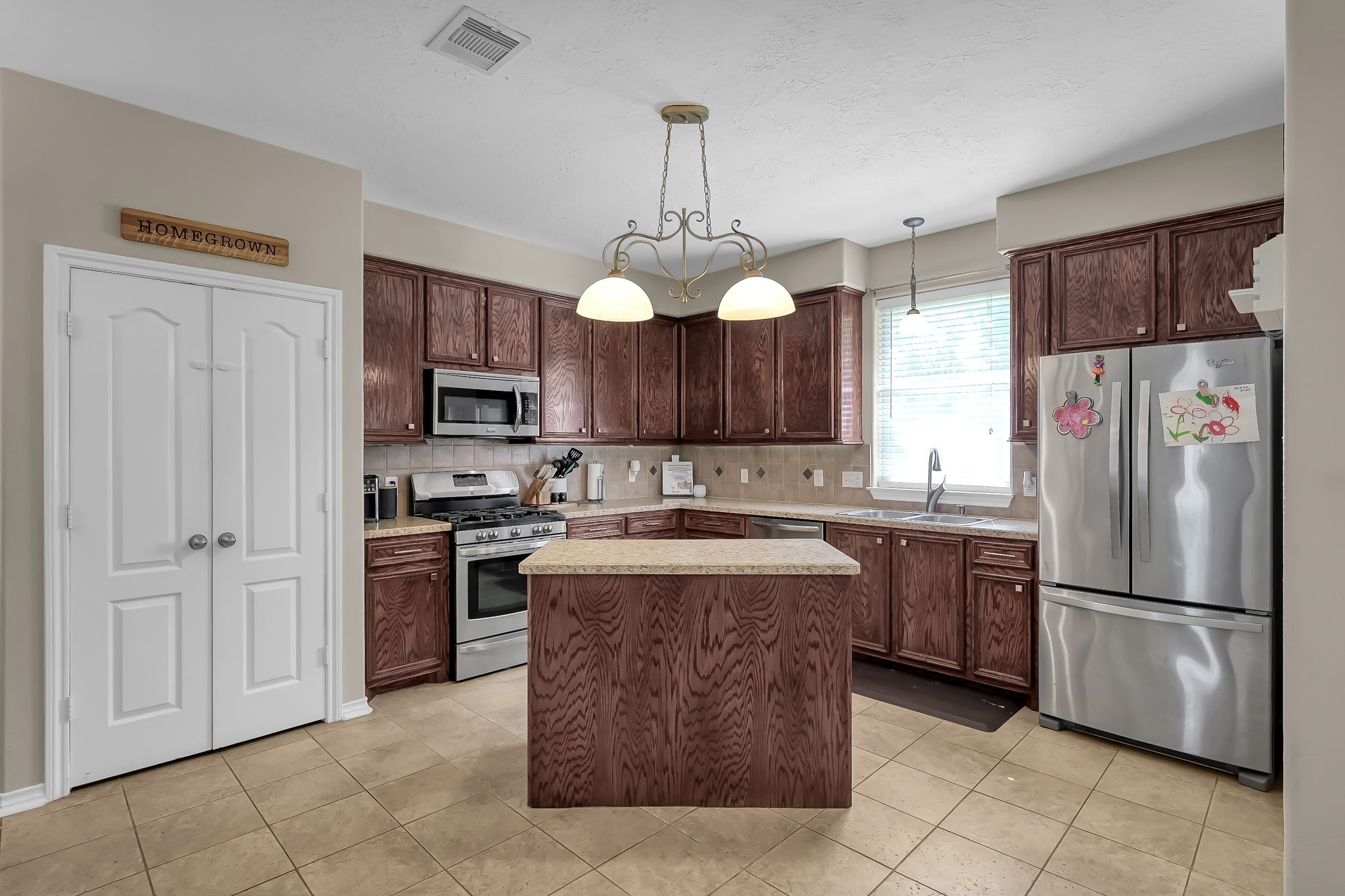409 Mildred Street Cleveland, TX 77328 - Photo 9 of 24 a kitchen with kitchen island granite countertop cabinets and stainless steel appliances