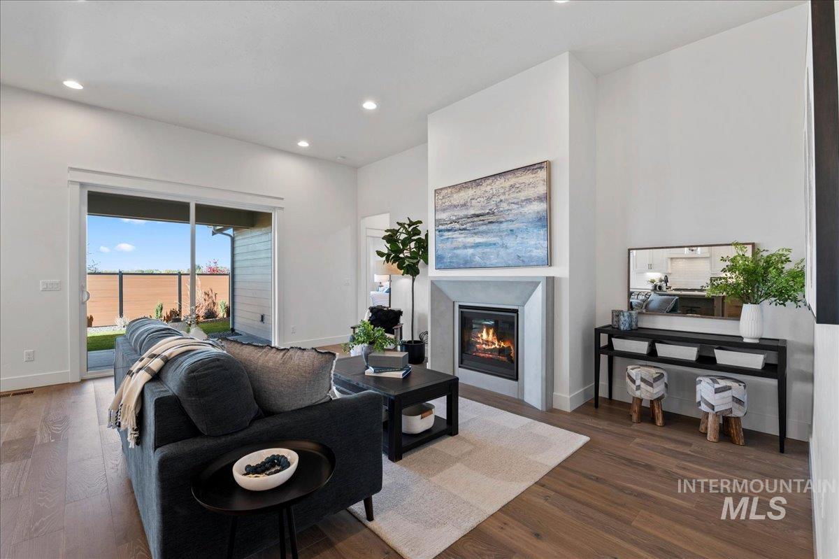8150 West Gallup Street Meridian, ID 83646 - Photo 14 of 30 Living room featuring a glass covered fireplace, dark wood-style flooring, and recessed lighting