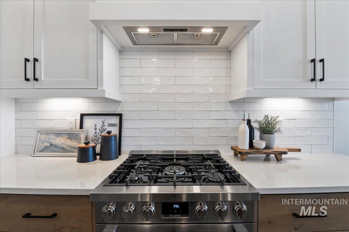 8150 West Gallup Street Meridian, ID 83646 - Photo 7 of 30 Kitchen featuring exhaust hood, backsplash, and stainless steel gas range oven