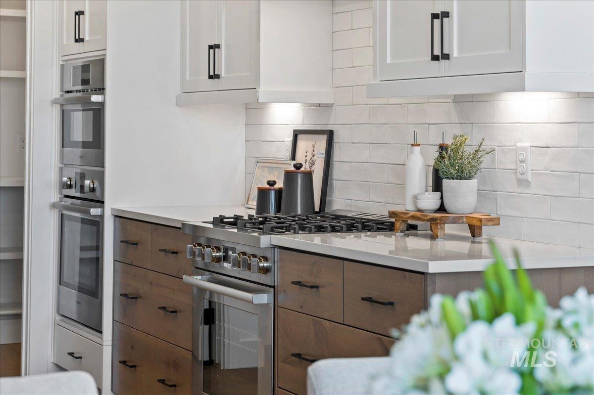 8150 West Gallup Street Meridian, ID 83646 - Photo 10 of 30 Kitchen with backsplash, appliances with stainless steel finishes, and white cabinetry