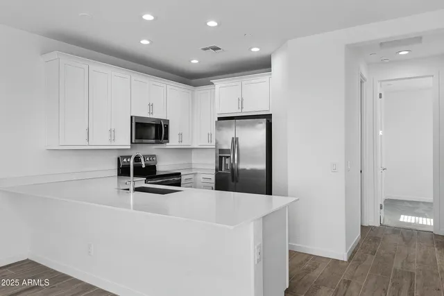 a kitchen with a refrigerator sink and cabinets