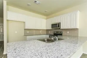 a kitchen that has a sink and a stove top oven