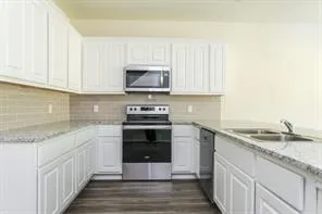 a kitchen with stainless steel appliances granite countertop a sink stove and microwave