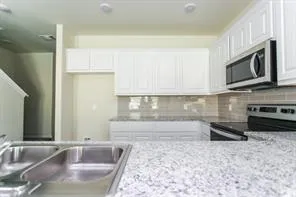 a kitchen with stainless steel appliances granite countertop a sink and a microwave