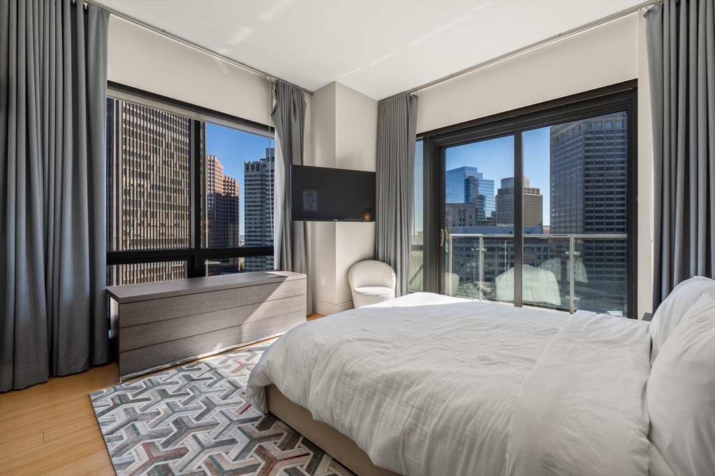 45 Province Street, Unit 2404 Boston, MA 02108 - Photo 20 of 32 a large bedroom with a bed and glass window