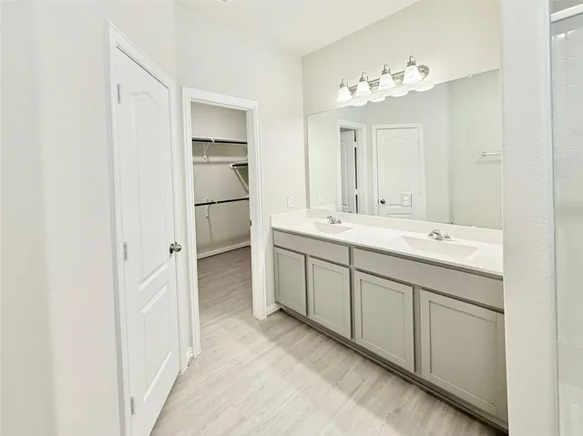 a spacious bathroom with a double vanity sink and a mirror