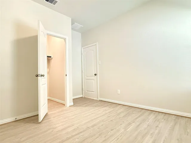 an empty room with wooden floor and closet