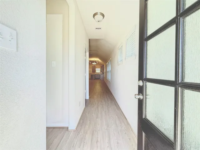 a view of a hallway with wooden floor and staircase