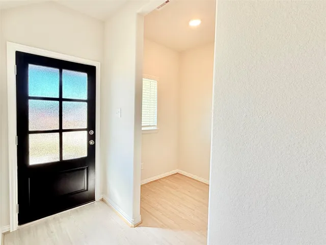a view of hallway with wooden floor and cabinet