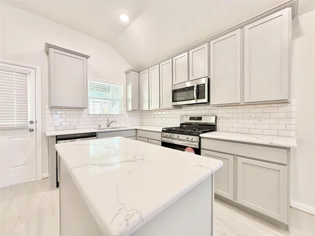 a kitchen with a sink a stove and cabinets