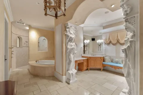 a bedroom with a large bed and a chandelier