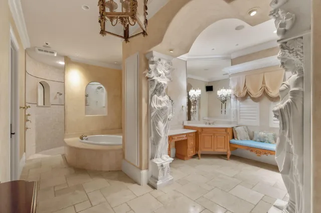 a bedroom with a large bed and a chandelier