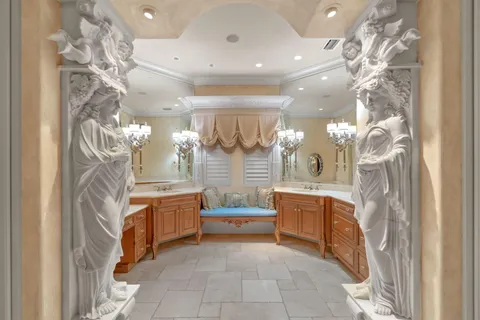 a bedroom with a bed chandelier and a window