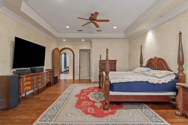 a bedroom with a bed chandelier and a window
