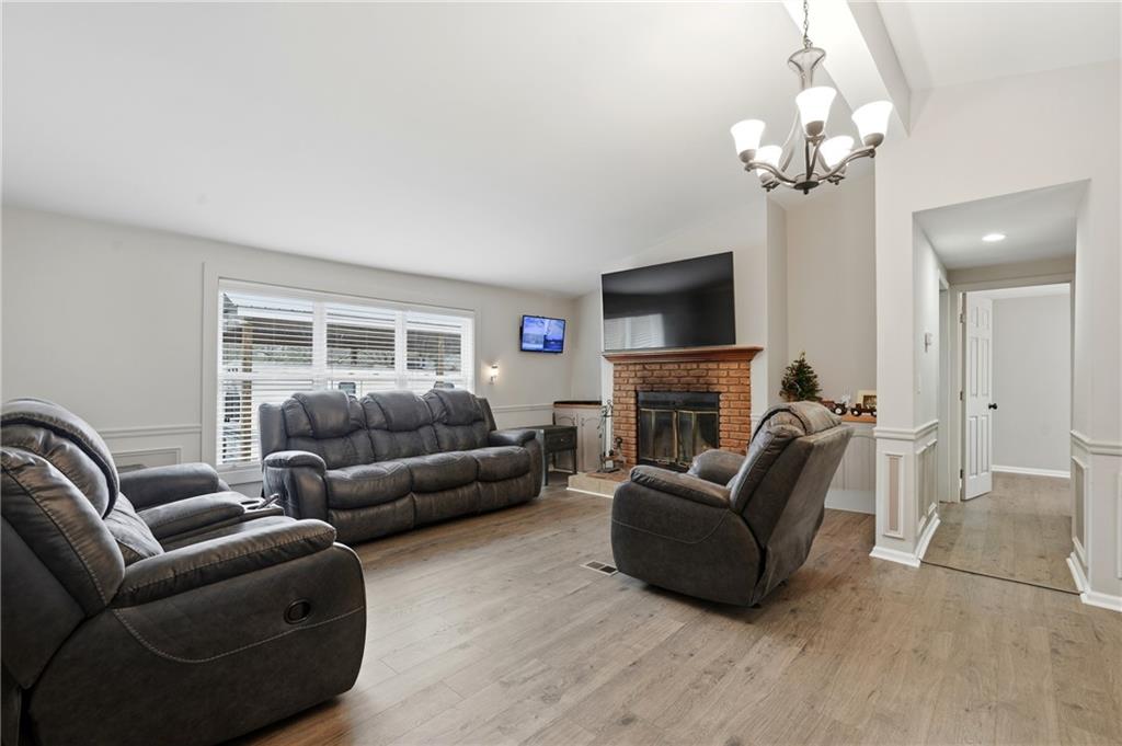 1295 Double Bridges Road Winder, GA 30680 - Photo 16 of 57 a living room with furniture a fireplace and a flat screen tv