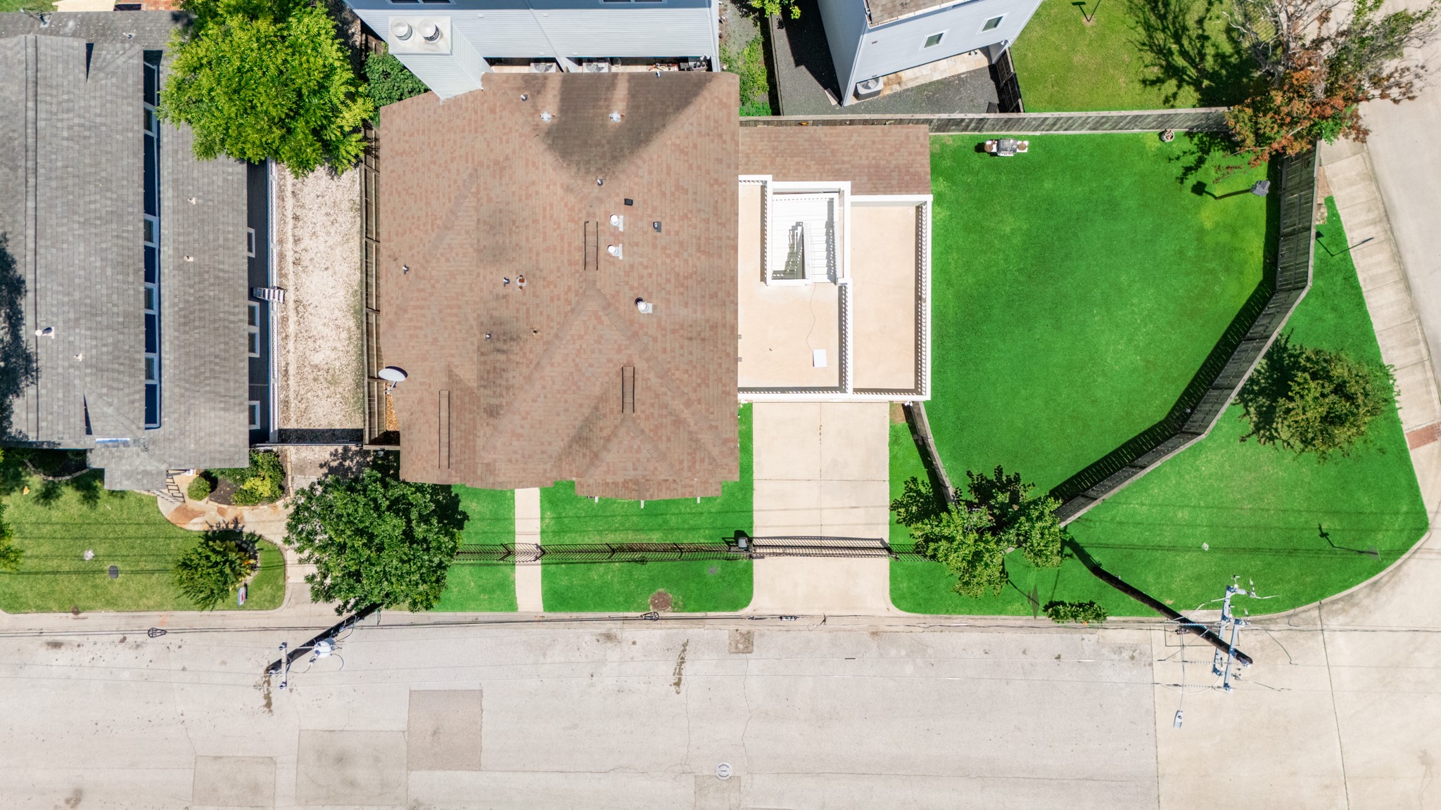 6621 North Main Street Houston, TX 77009 - Photo 35 of 41 This aerial view showcases a spacious property with a large, well-maintained lawn and a driveway. The house features a brown roof and is flanked by neighboring homes, offering a blend of privacy and community.