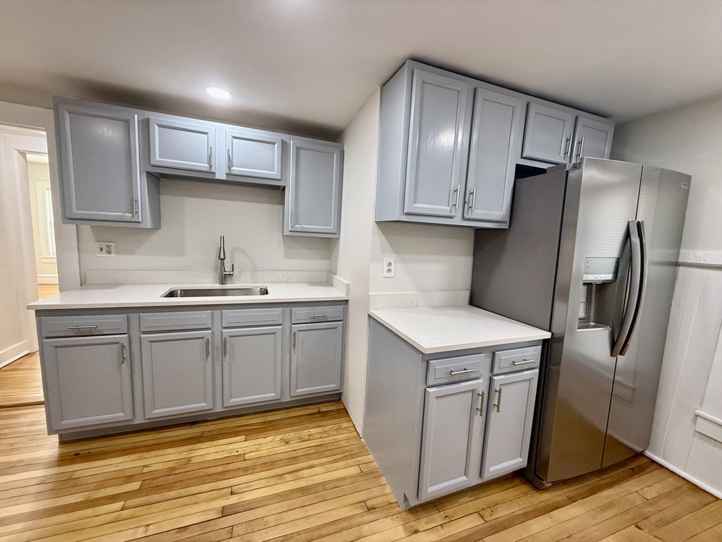 a kitchen with stainless steel appliances sink refrigerator and cabinets