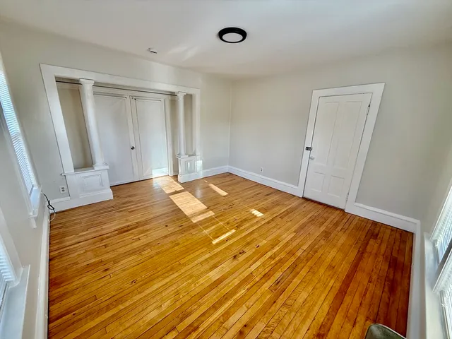 a view of an empty room with wooden floor