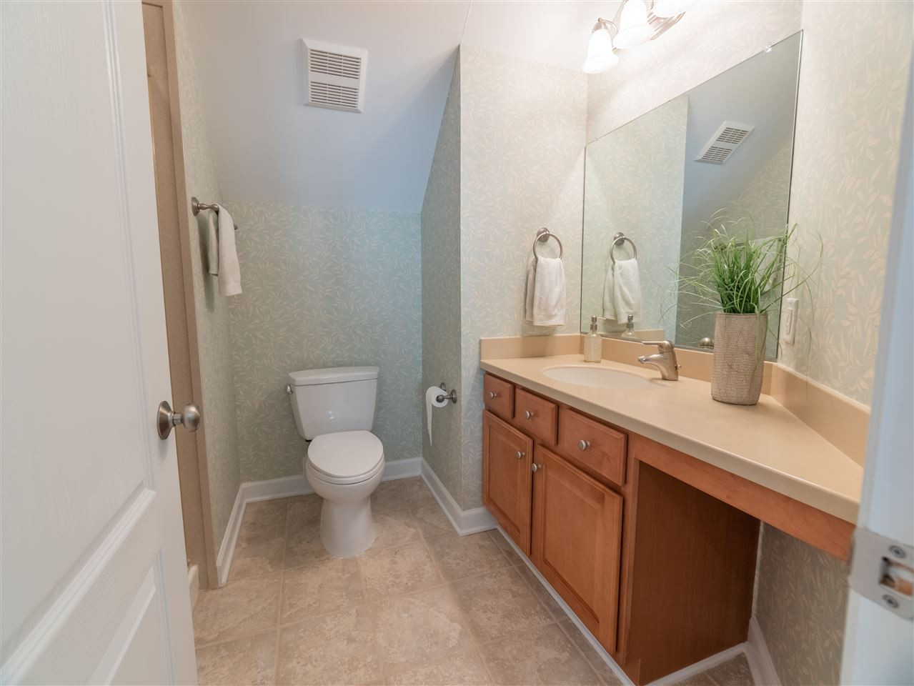 4016 White Chapel Way Raleigh, NC 27615 - Photo 25 of 30 Full bath on 3rd level features tile flooring, comfort height cabinet with Corian top and integrated sink, brushed nickel fixtures, Toto commode and full Corian walk-in shower.