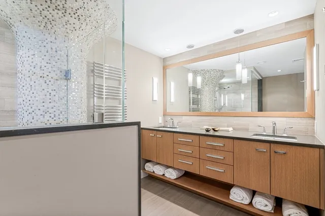 a bathroom with a granite countertop sink and a large mirror