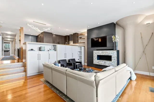 a living room with furniture a flat screen tv and a fireplace