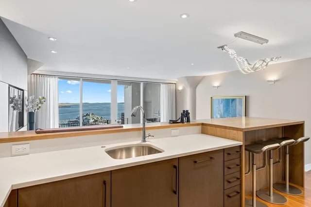 a view of a kitchen with a sink and large window