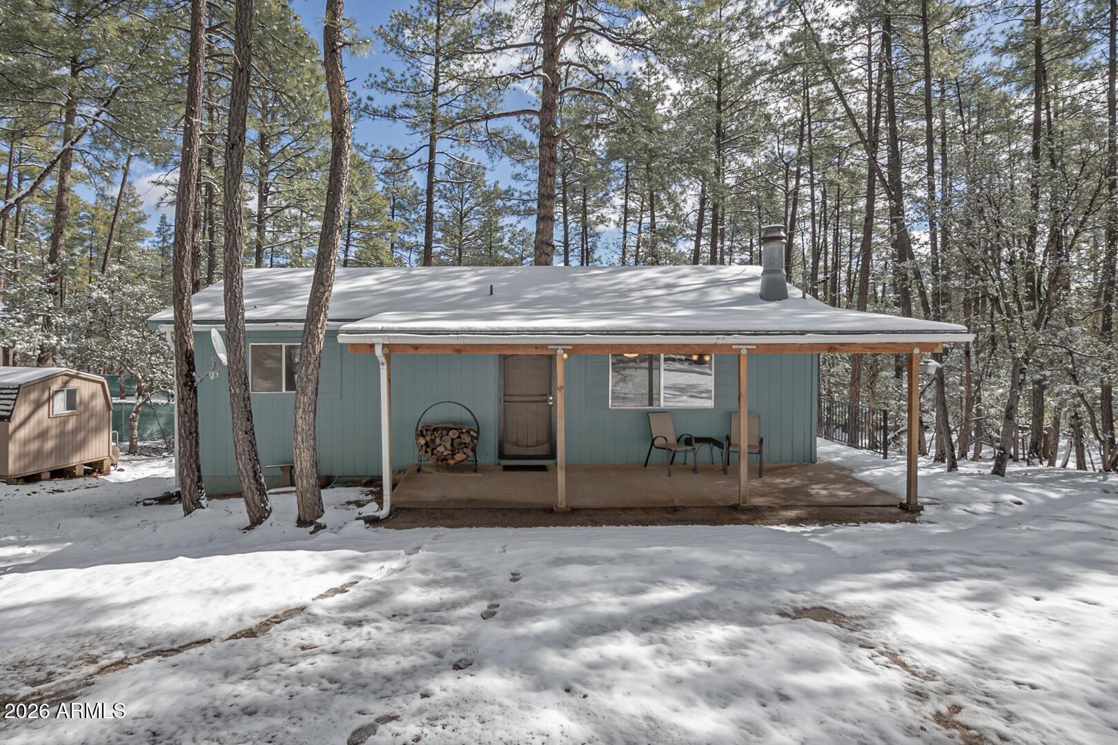 3741 Cochise Lane Pine, AZ 85544 - Photo 1 of 21 a view of a house with large trees and wooden fence