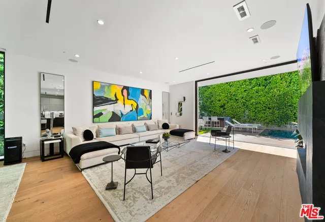 a living room with couches a coffee table and a flat screen tv