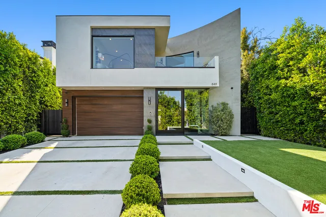 a front view of a house with a yard and trees