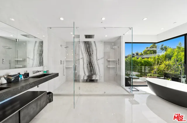 a bathroom with a tub a sink and mirror
