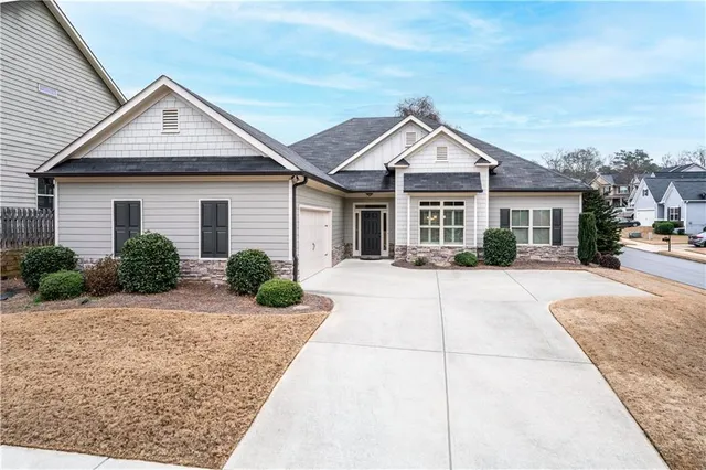 a view of a house with a yard and large tree