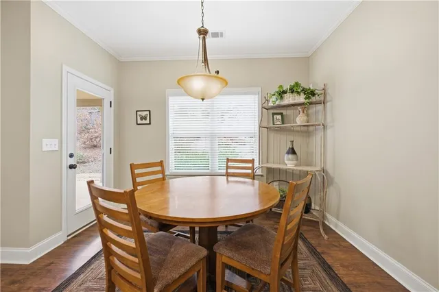 a dining room with furniture a chandelier and wooden floor