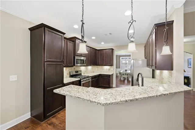 a kitchen with stainless steel appliances granite countertop a refrigerator a sink and a refrigerator