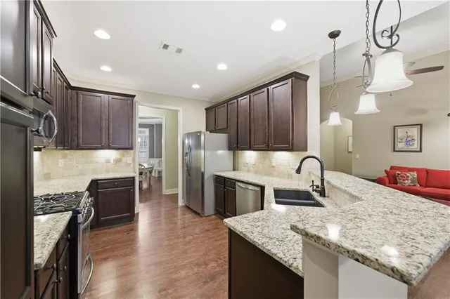 a kitchen with stainless steel appliances granite countertop a sink refrigerator and cabinets