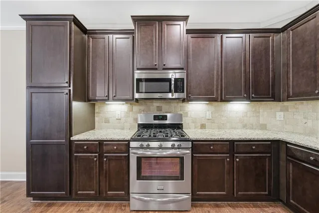 a kitchen with granite countertop a stove and a refrigerator