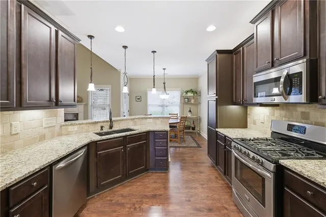 a kitchen with stainless steel appliances granite countertop a sink stove and refrigerator